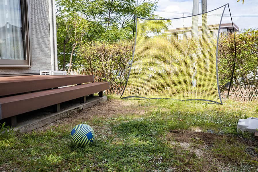 リバウンドネットを設置した庭とサッカーボール